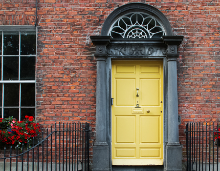 Traditional entrance door of yellow color in Irish town.の写真素材