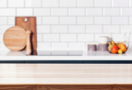 Wooden table in front of blurred modern kitchen. Interior background.の写真素材