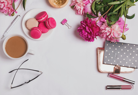 Feminine accessories, coffee with milk and pink peonies on the white background, top viewの写真素材