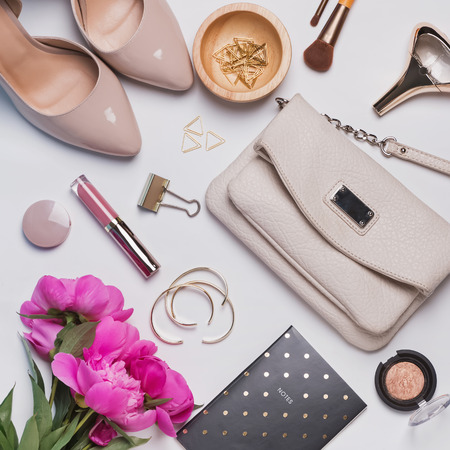 Woman's accessories and pink peonies on white background, top viewの写真素材