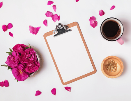 Clipboard with empty paper, coffee and pink roses, top view. Summer mock-up.の写真素材