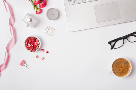 Feminine workplace with coffee, laptop and small accessories, top viewの写真素材