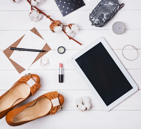 Flat lay with cotton branch, shoes and tablet on the white backgriundの写真素材