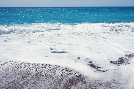 Waves with white foam at beautiful seaの写真素材
