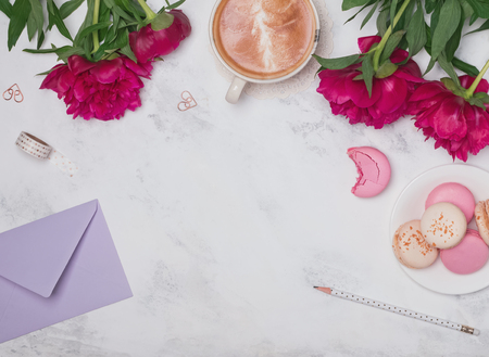 Coffee, pink peonies and macarons on the marble backgroundの写真素材