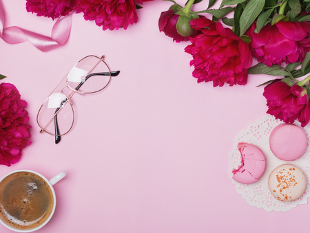 Peonies, coffee and macarons on the pink backgroundの写真素材