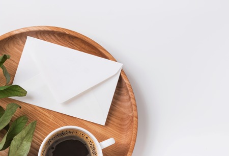 Envelope and coffee on the wooden trayの写真素材