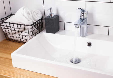 Details of modern bathroom with wite tile and wooden tableの写真素材