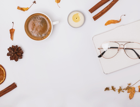 Autumn flat lay with coffee, candle and yellow leavesの写真素材