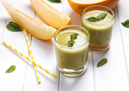 Delicious refreshing melon smoothie on the white tableの写真素材