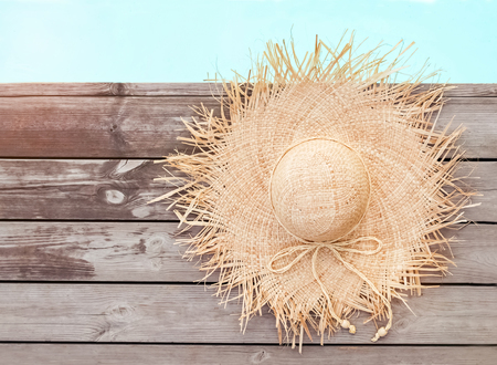 Beautiful feminine straw hat lying near the swimming poolの写真素材