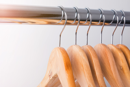 Wooden hangers on rail close-up.の写真素材