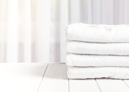 Clean white towels in stack on the white table.の写真素材