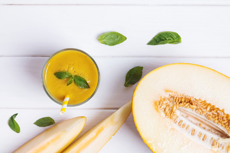 Delicious refreshing melon smoothie on the white wooden table top viewの写真素材