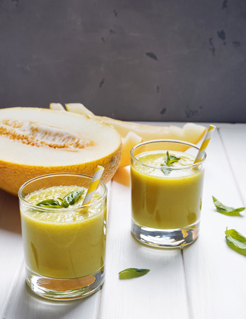 Delicious refreshing melon smoothie on the white wooden table close-upの写真素材