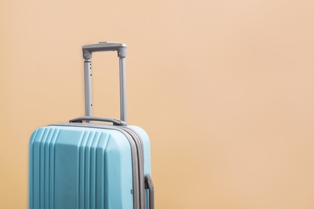 Blue plastic suitacase for travel on bright background with copy spaceの写真素材