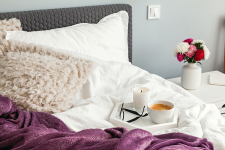 Tray with coffee standing on the bedwith white linenの写真素材