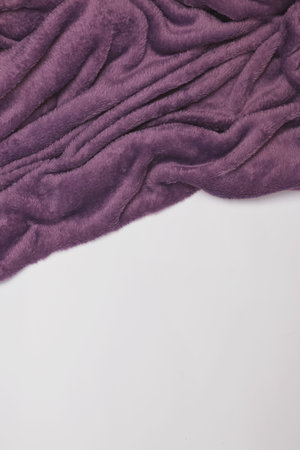 Purple soft blanket on the white bed, top view.の写真素材