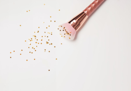 Pink make-up brush with small colden stars on the white background. Beauty concept.の写真素材