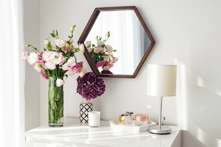 Light room with mirrow, flowers, night lamp and other objectsの写真素材