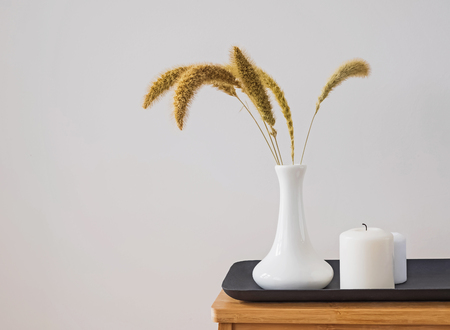 Dry ears in the vase and candles on the small table.の写真素材