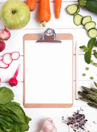 Empty paper mock-up in the cener of different vegetables and fruits, top viewの写真素材