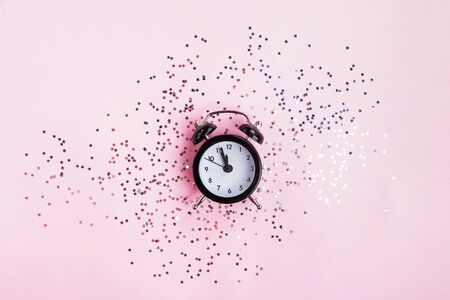New Year or Christmas concept with clock showing around twelve pm and gold star shaped confettiの写真素材