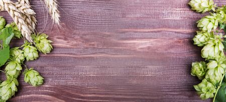 Hop cones and wheat ears on the wooden background, top view.の写真素材