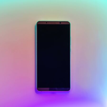 Smarphone with empty screen isolated in neon lightの写真素材