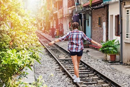 Woman tourist walking over the famous touristick tsrain street in Hanoi, Vietnam.の写真素材