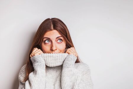 Portrait of a happy young woman in warm cozy sweater.の写真素材