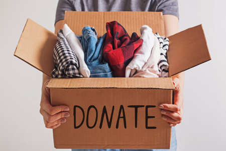 Woman holding a box with clothing close-up.