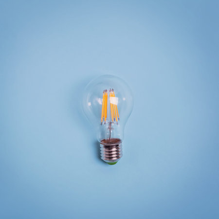 Retro electric light bulb isolated on blue background. Creativity, new ideas concept.