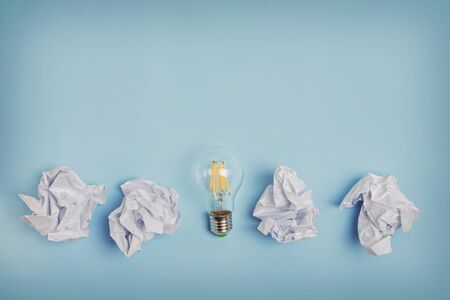 Crumpled papers and lightbulb on the blue background.の写真素材
