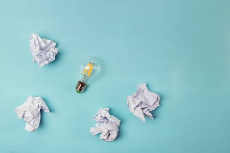 Crumpled papers and lightbulb on the blue background.の写真素材