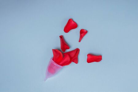 Feminine menstrual cups from a medicinal silicone with red rose petals symbolizing blood.の写真素材
