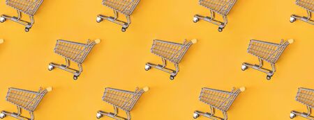 Shopping trolleys lying on a bright yellow background.の写真素材