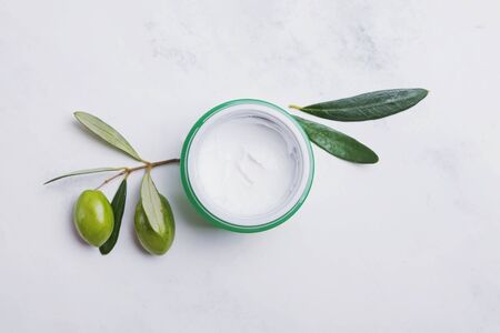 Natural moisturizing cream with olive extract on the white marble tablem top view.の写真素材