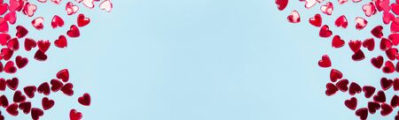 Red heart shaped confetti on blue background, top view. Valentine's day banner with place for textの写真素材