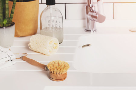 Natural material dish washing brush on white countertop close-up.