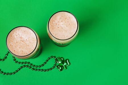 Two glasses of dark stout beer and traditional clover shaped decorの写真素材