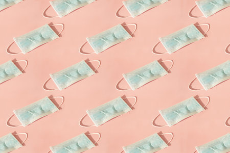 Pattern of Medical mask on pink background, flat lay top view.
