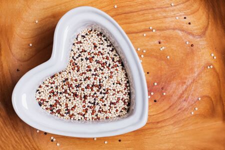 Tricolour quinoa grain super food in heart shaped bowl, top view.の写真素材