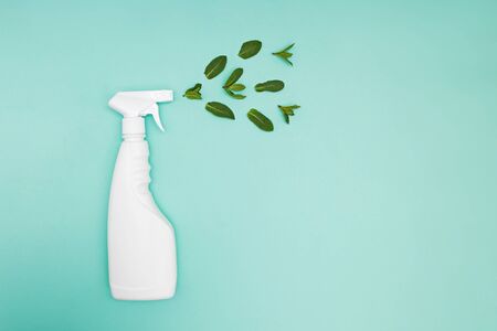 Detergent spray bottle on a green background with fresh mint leaves. Creative composition, natural cleaning products, eco cleaning conceptの写真素材