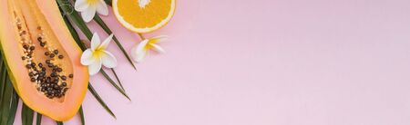 Banner format summer composition with palm leaves, papaya and orange. Tropical background.の写真素材