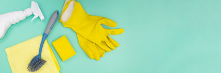 Cleaning tools and supplies on green background, top view.