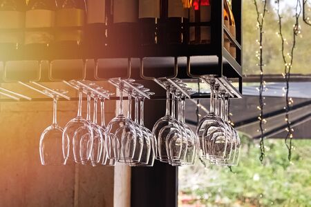Clean glasses for wine hang in fastenings in even rows in a bar or restaurantの写真素材