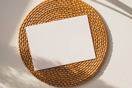 Card mock-up on round woven straw mat.の写真素材