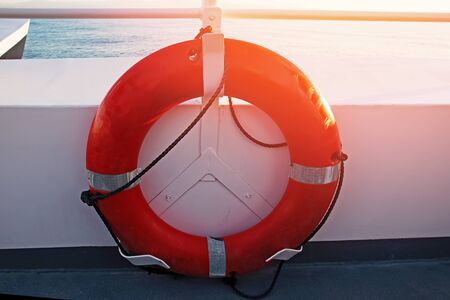 Red lifebuoy on the boat in sunset lightの写真素材