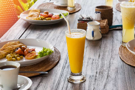 Healthy breakfast with omellete, salad, juice and coffee on wooden tableの写真素材